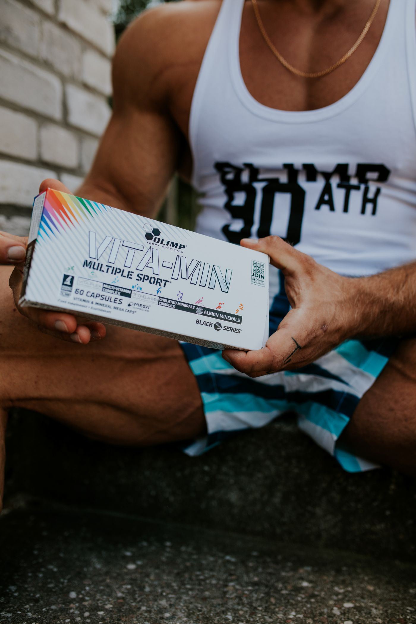 Caja de Vita-min Multiple Sport de Olimp en las manos de un deportista